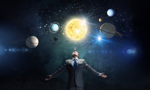 Young businessman looking at planets of sun system